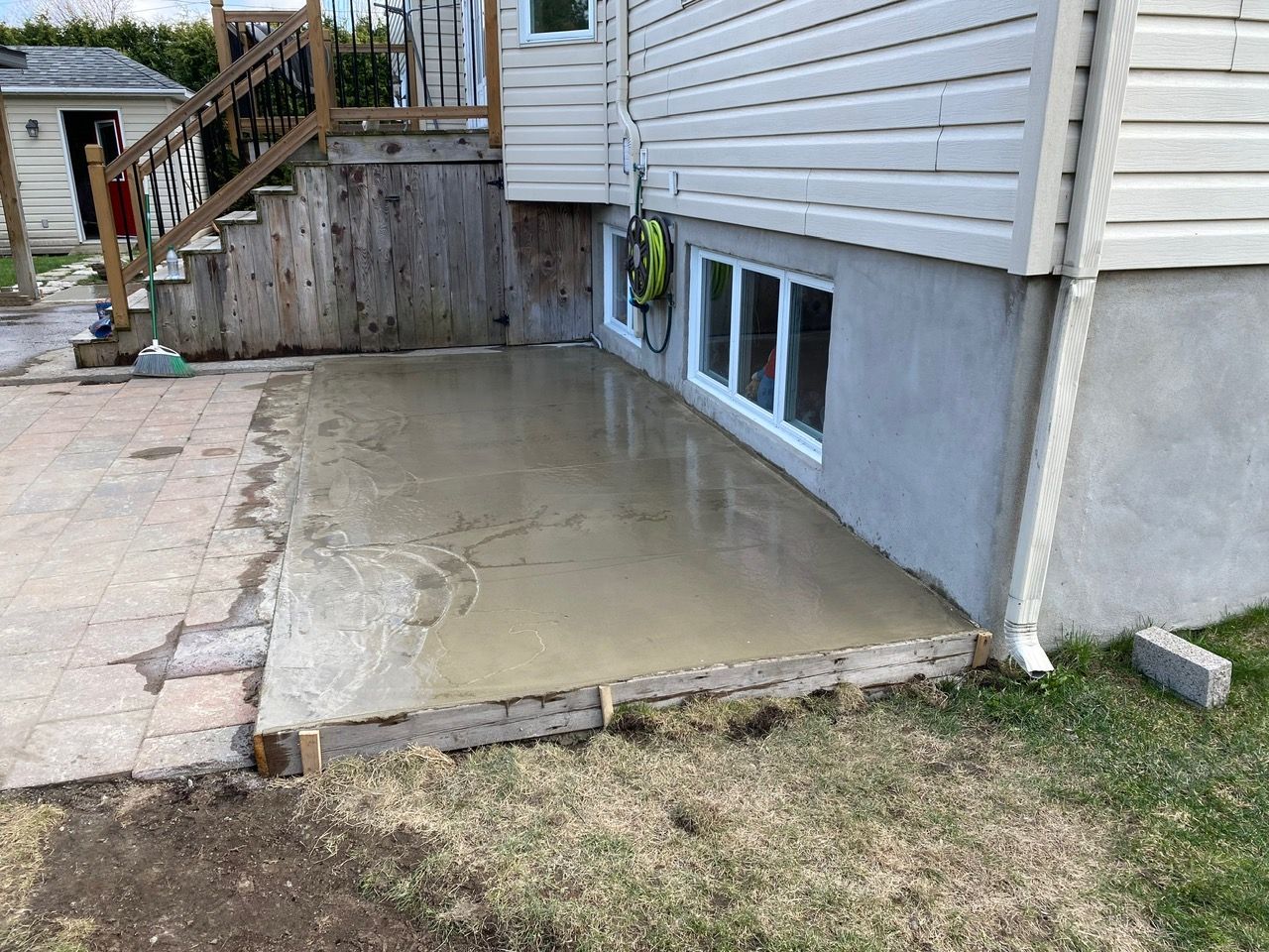 Une terrasse en béton est en cours de construction devant une maison.