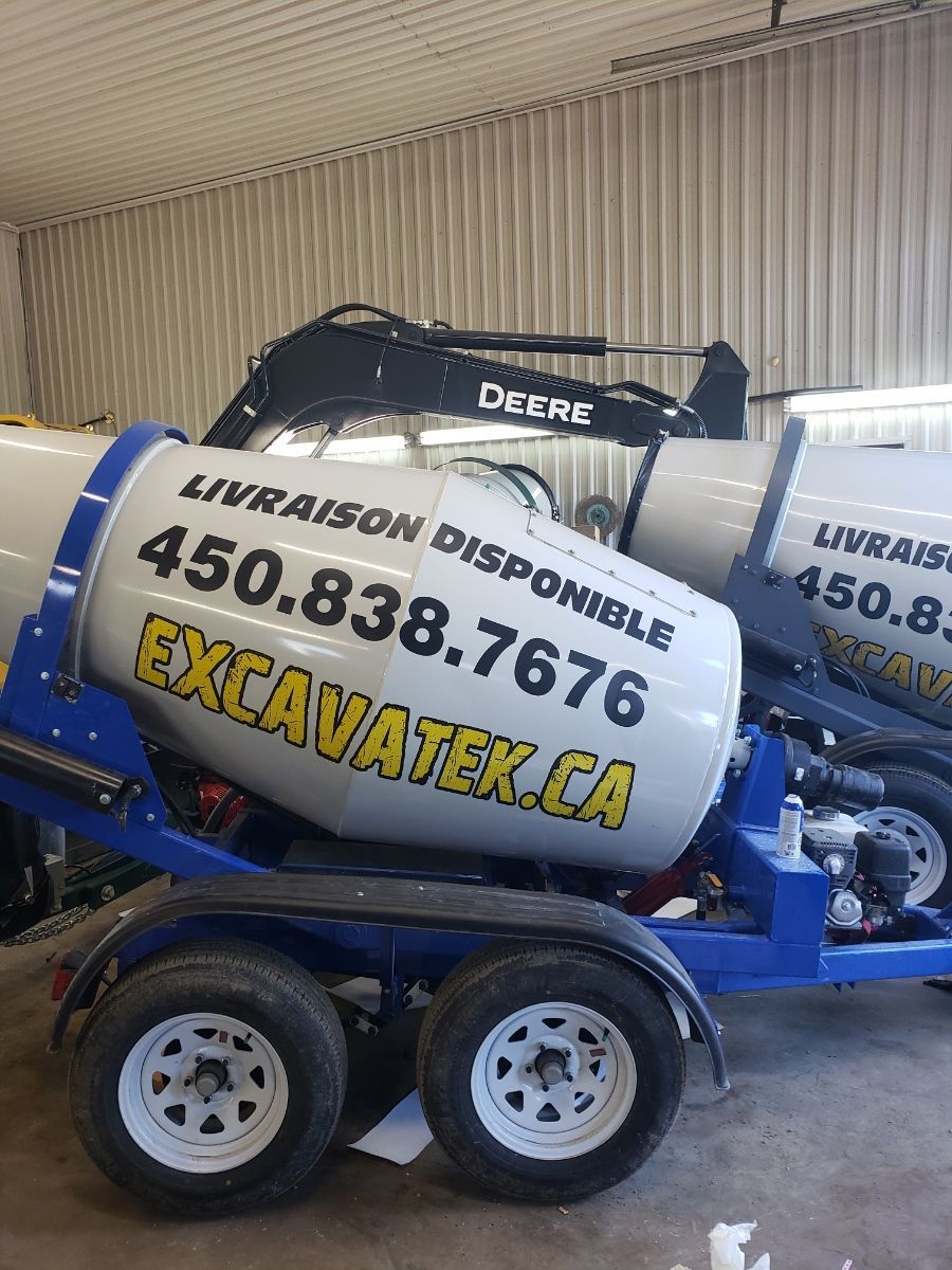 Une bétonnière est sur une remorque dans un garage.