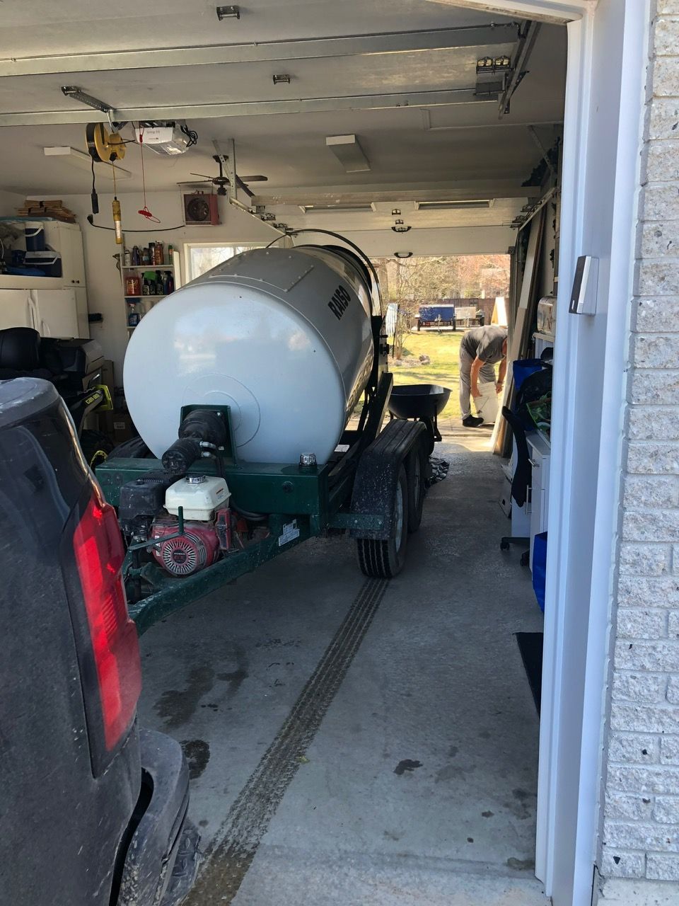 Un grand réservoir blanc est sur une remorque dans un garage