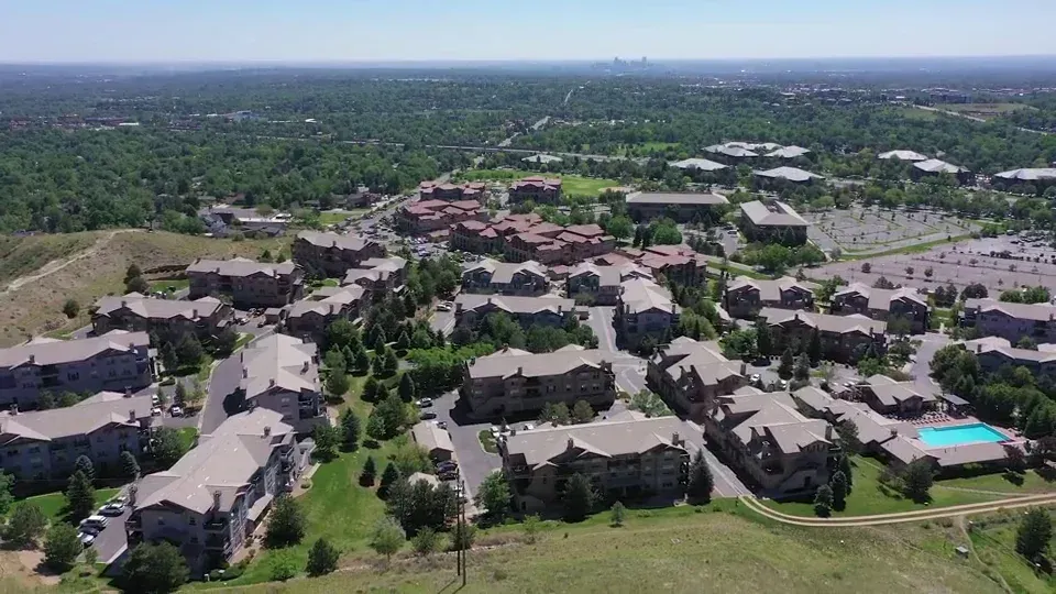 Aerial view of a large apartment community with many buildings and a visible pool.