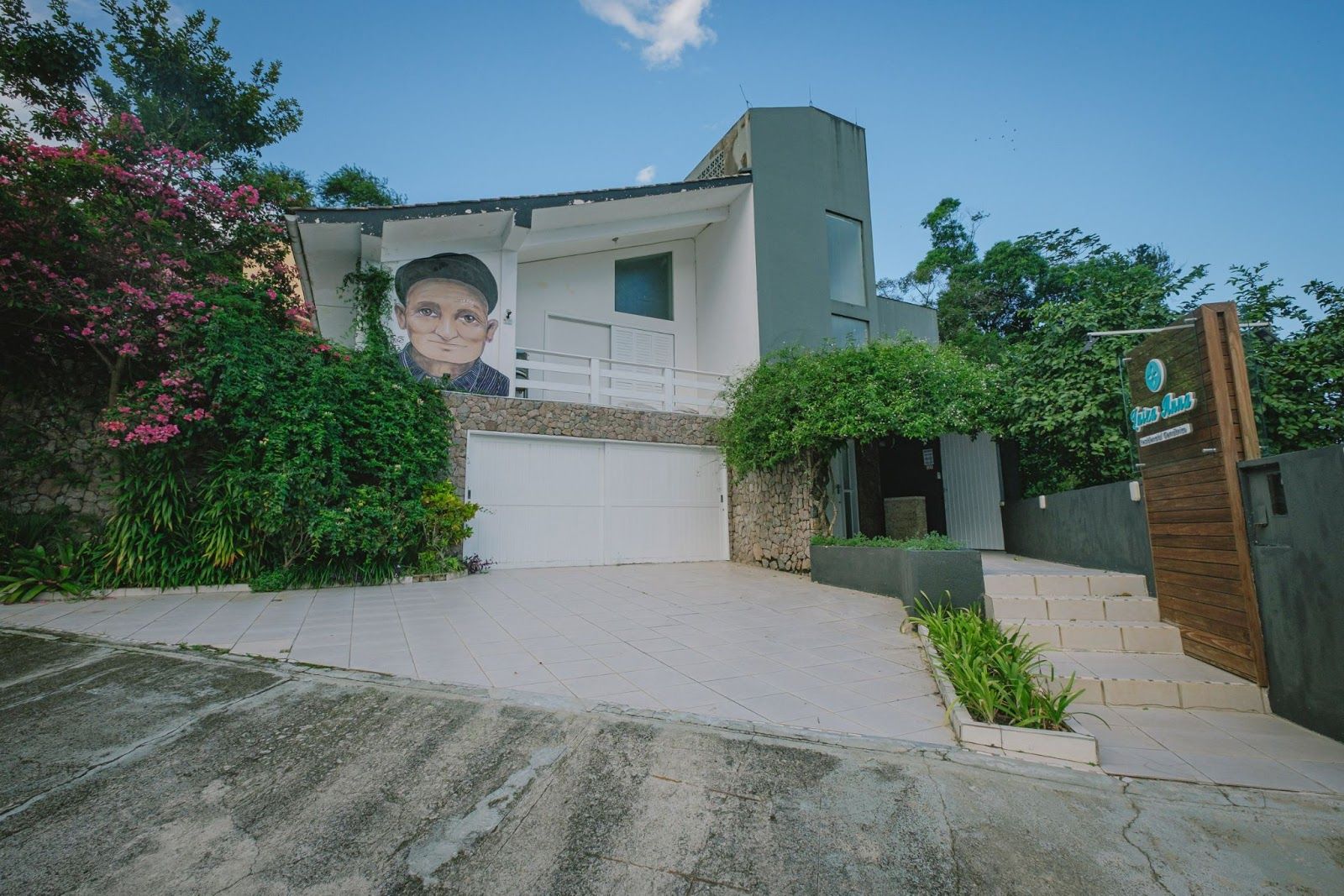 Uma casa grande com a pintura de um homem ao lado.