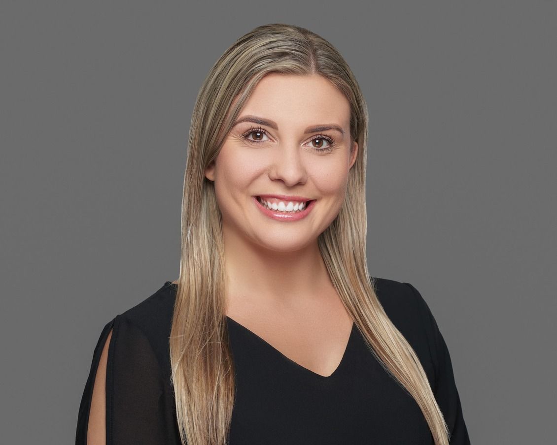 Me, Chelsea Renae, with blonde hair smiling, wearing a black top, against a gray background.