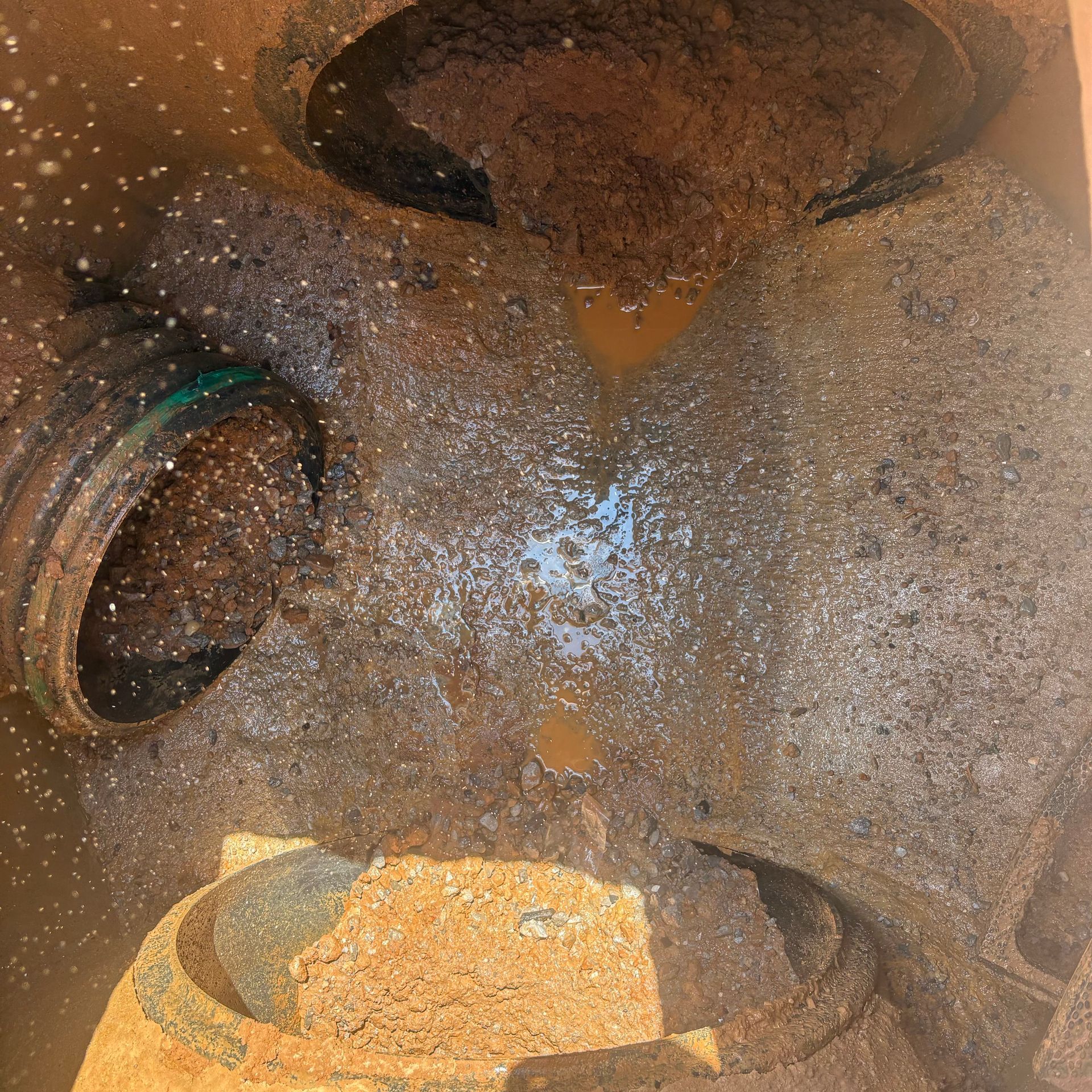 Close-up of two rusty metal pipes or vents with a green ring inside one opening.