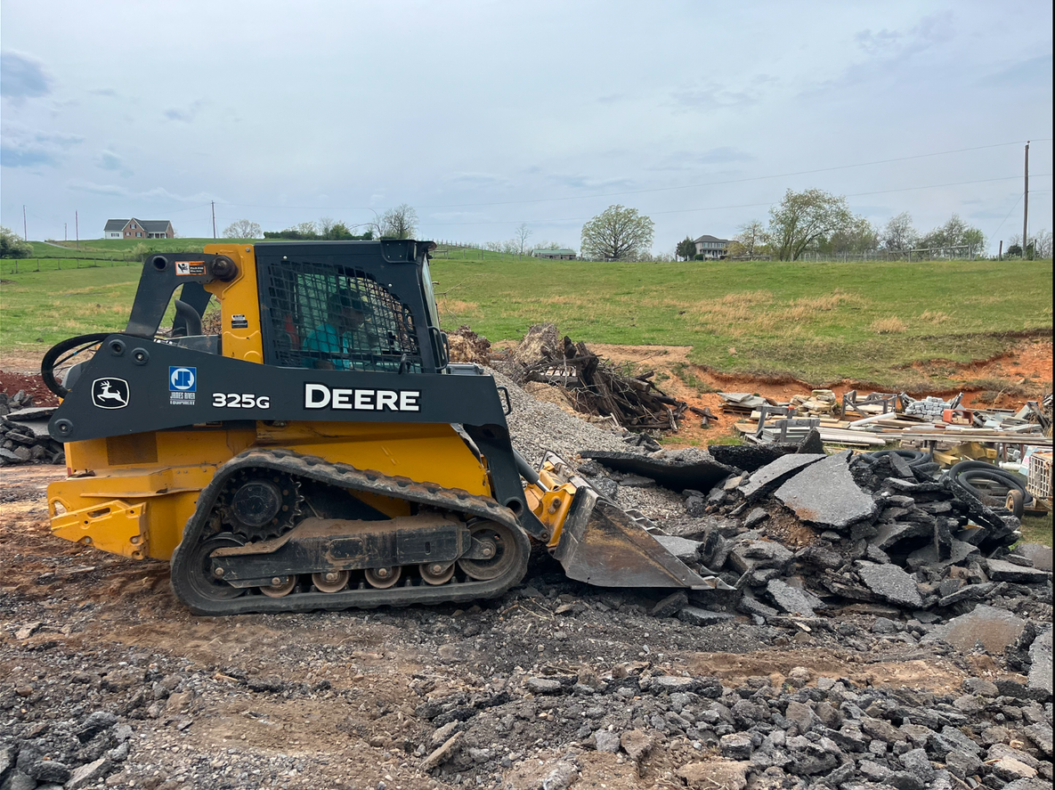 A large yellow excavator is demolishing a building.