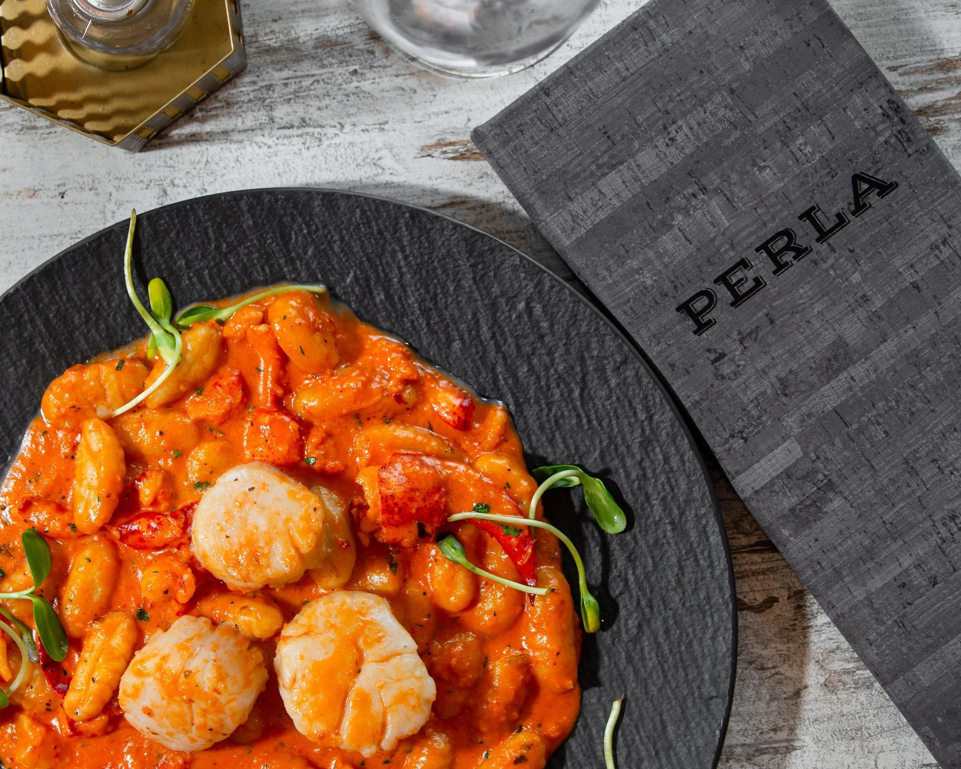 A plate of food next to a napkin that says perla