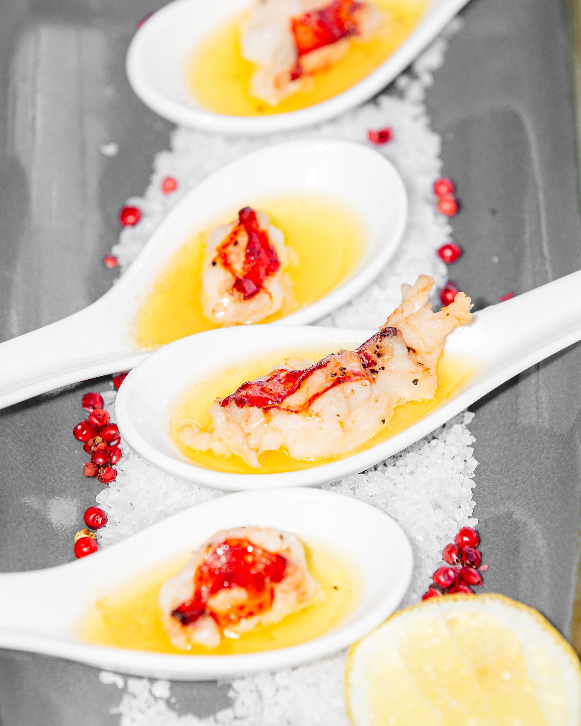 A row of spoons filled with food on a table
