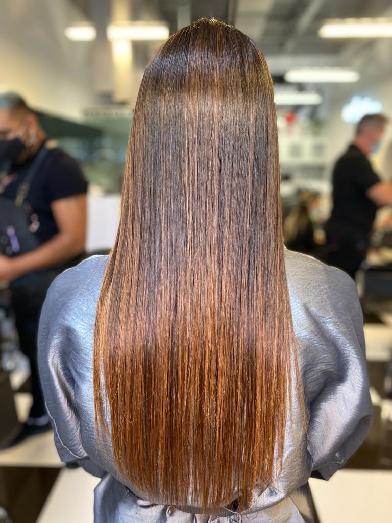 The back of a woman 's hair is shown in a salon.