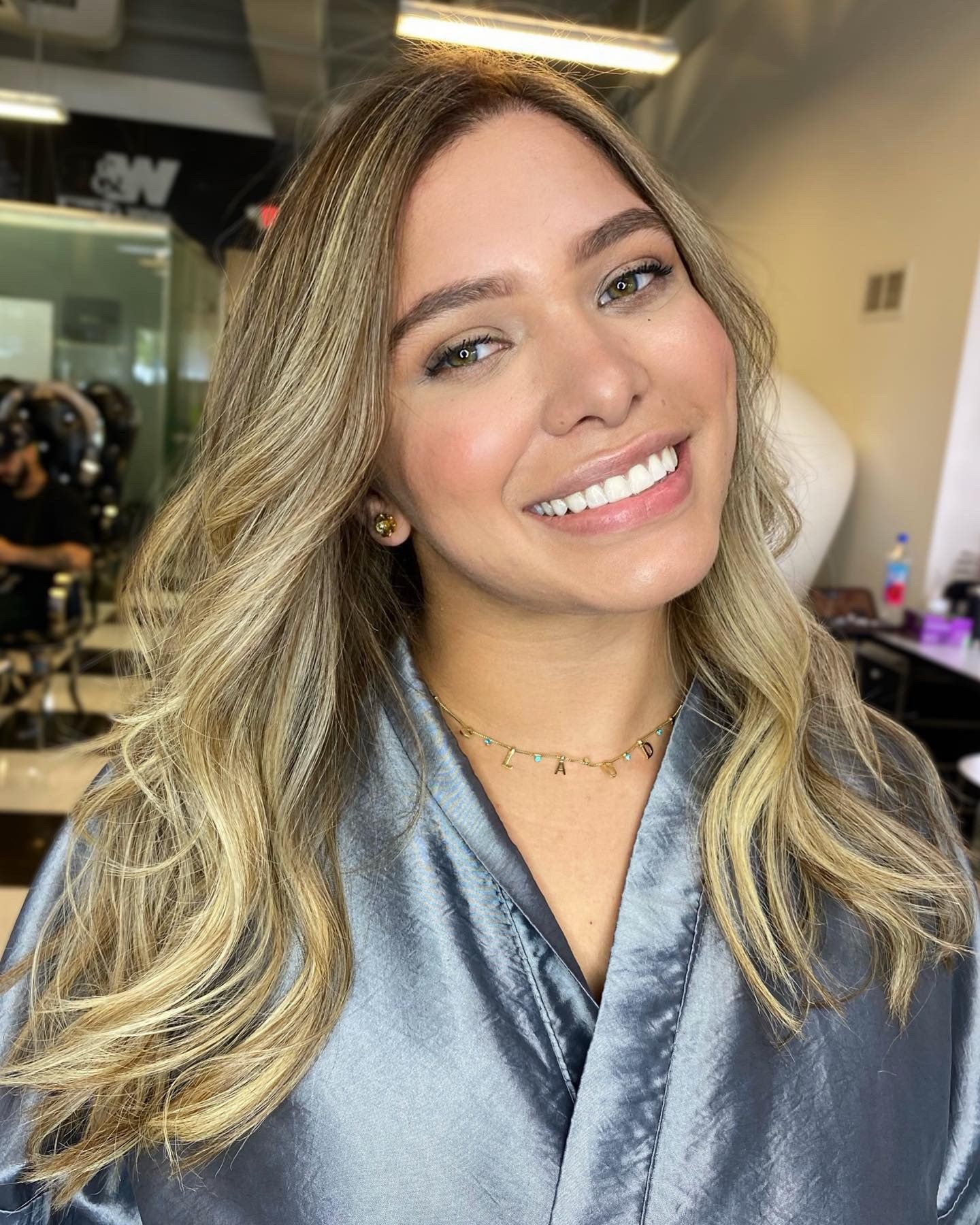 A woman in a grey robe is smiling for the camera.