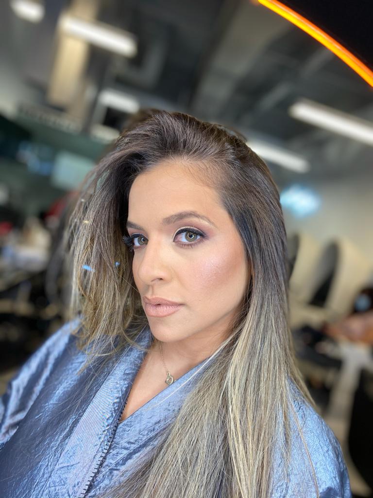 A woman in a blue robe is getting her hair done in a salon.