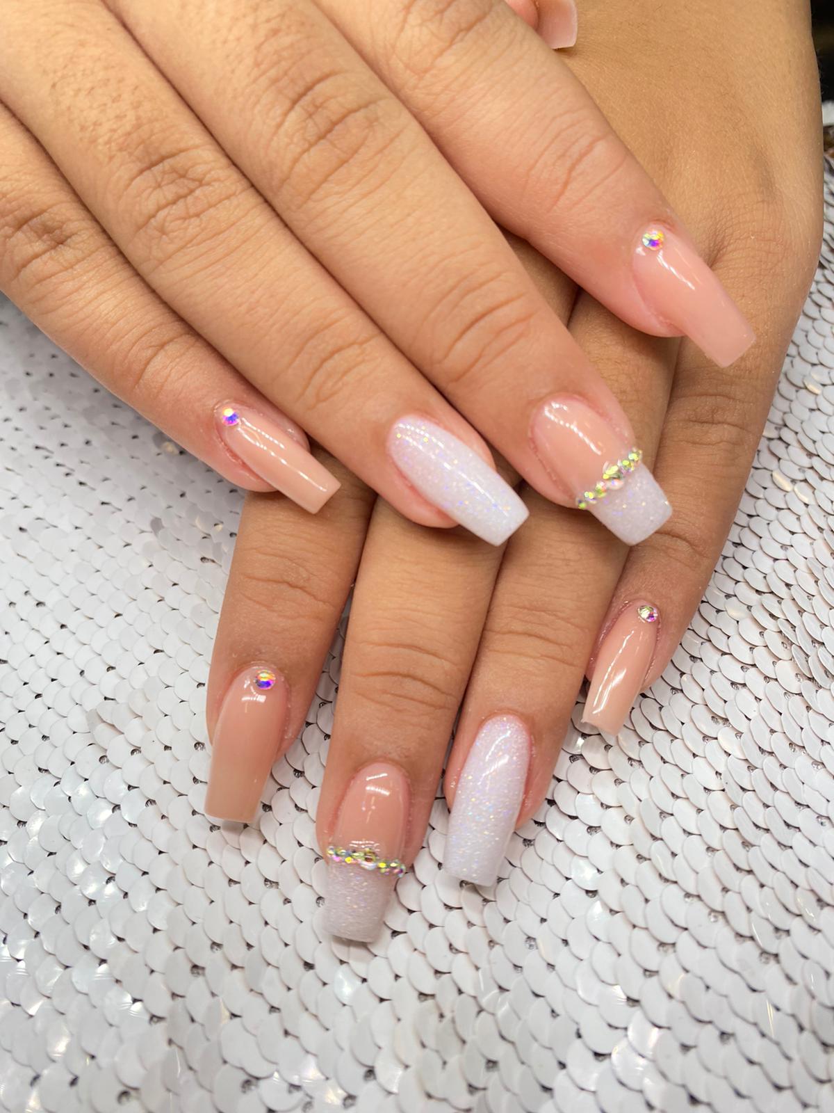 A close up of a woman 's nails with rhinestones on them