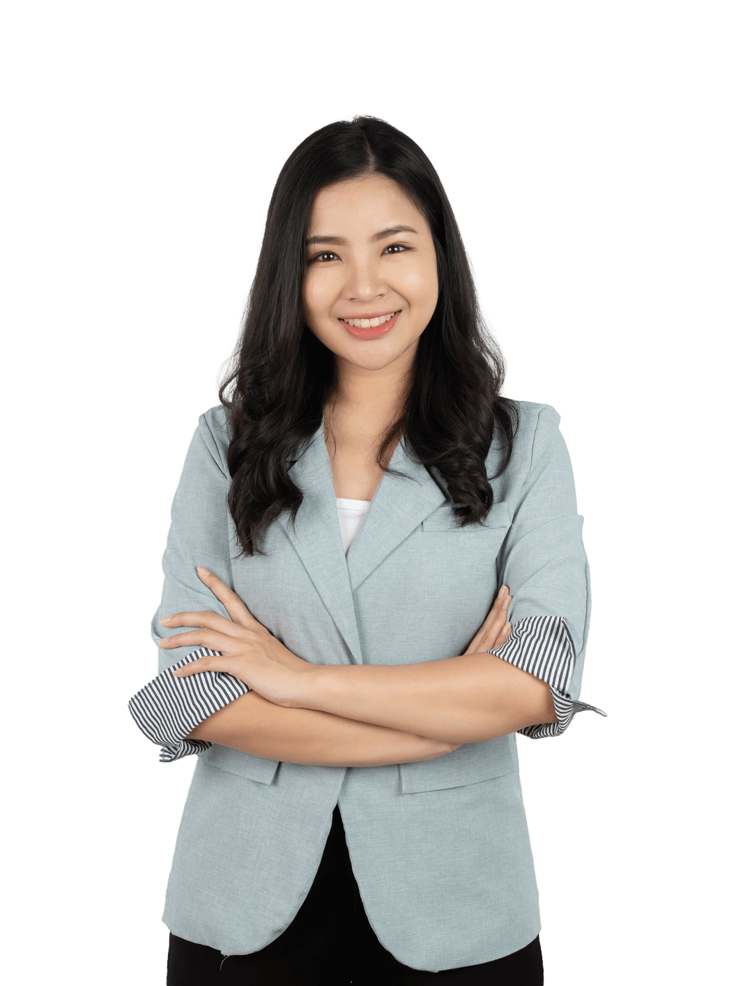 A woman in a blue jacket is standing with her arms crossed and smiling.