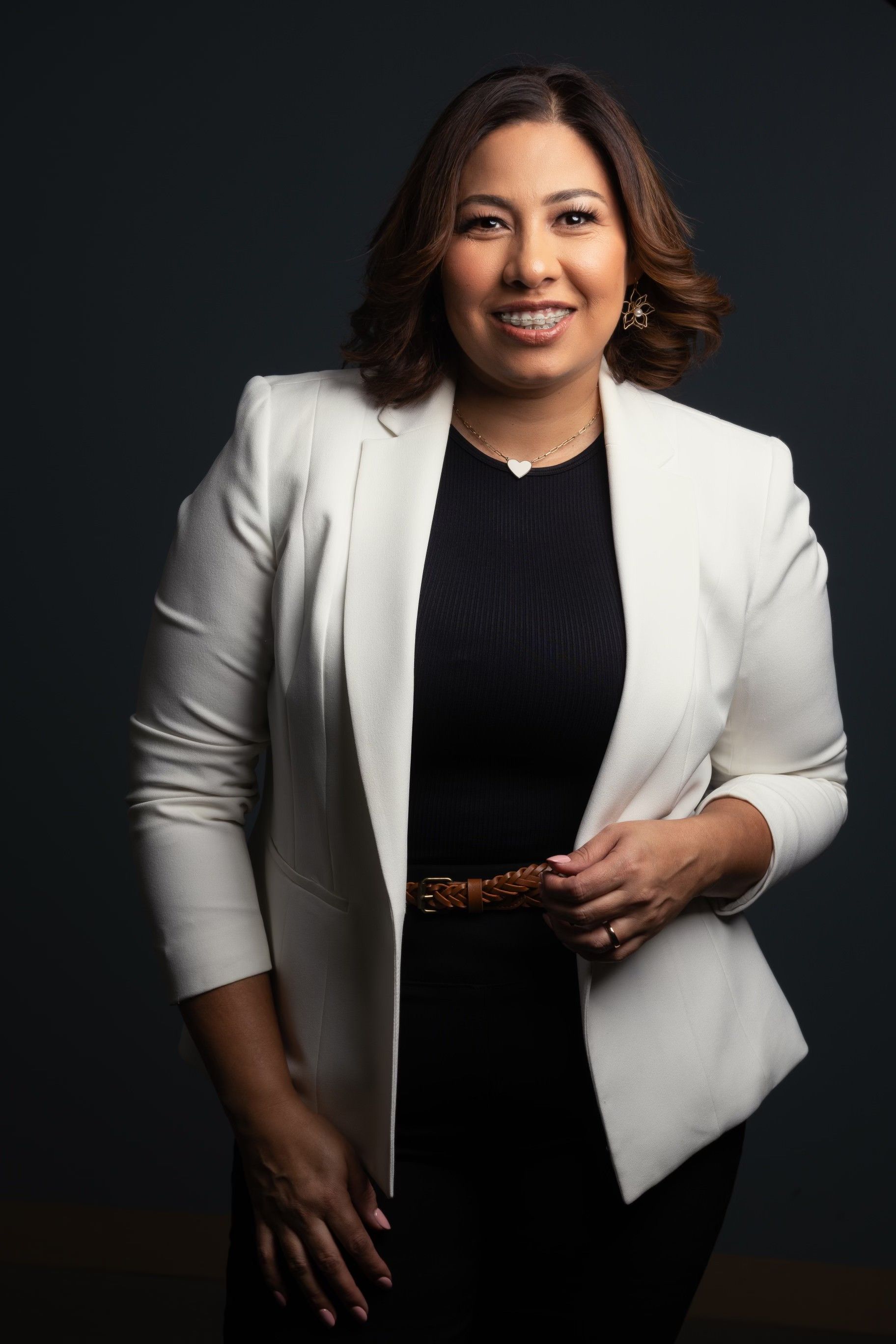 A woman is wearing a white jacket and a black dress.