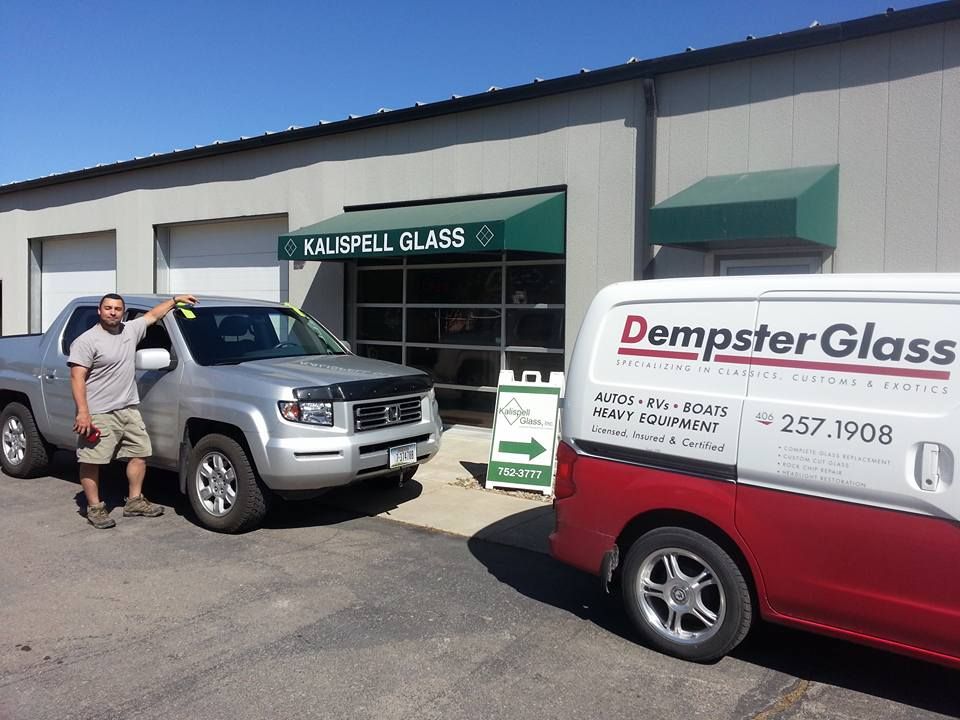Man stands by silver truck outside 