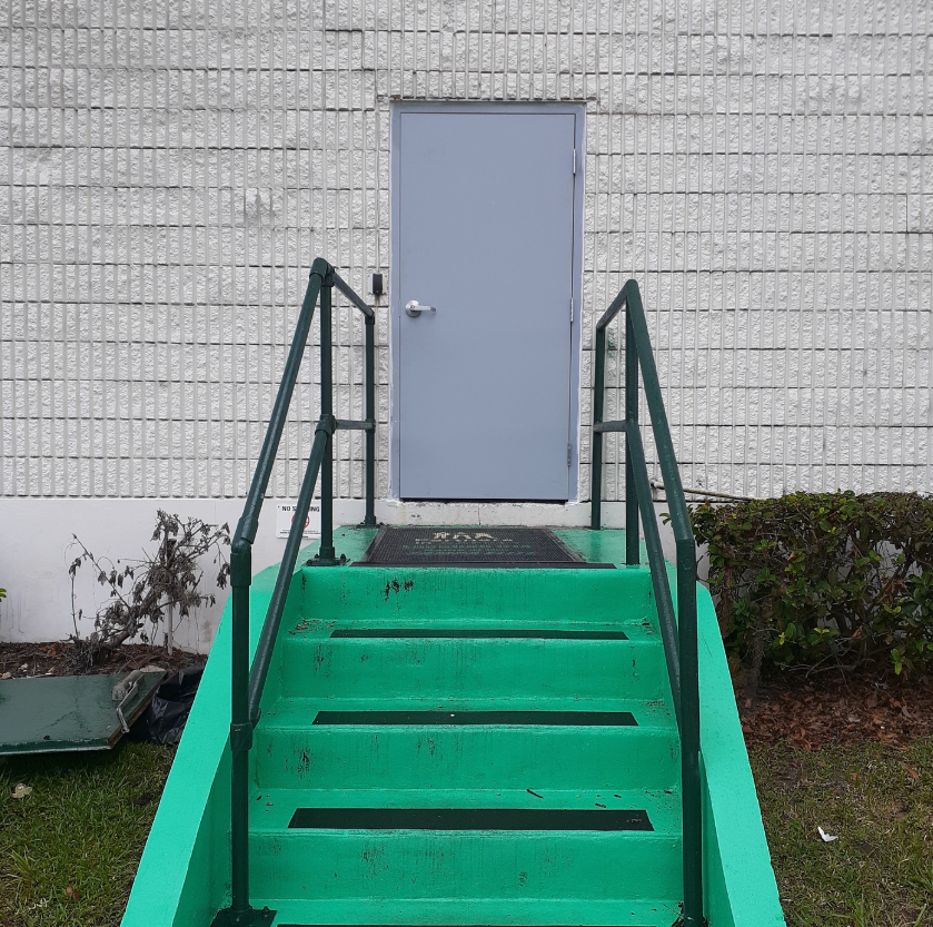 A set of green stairs leading up to a door