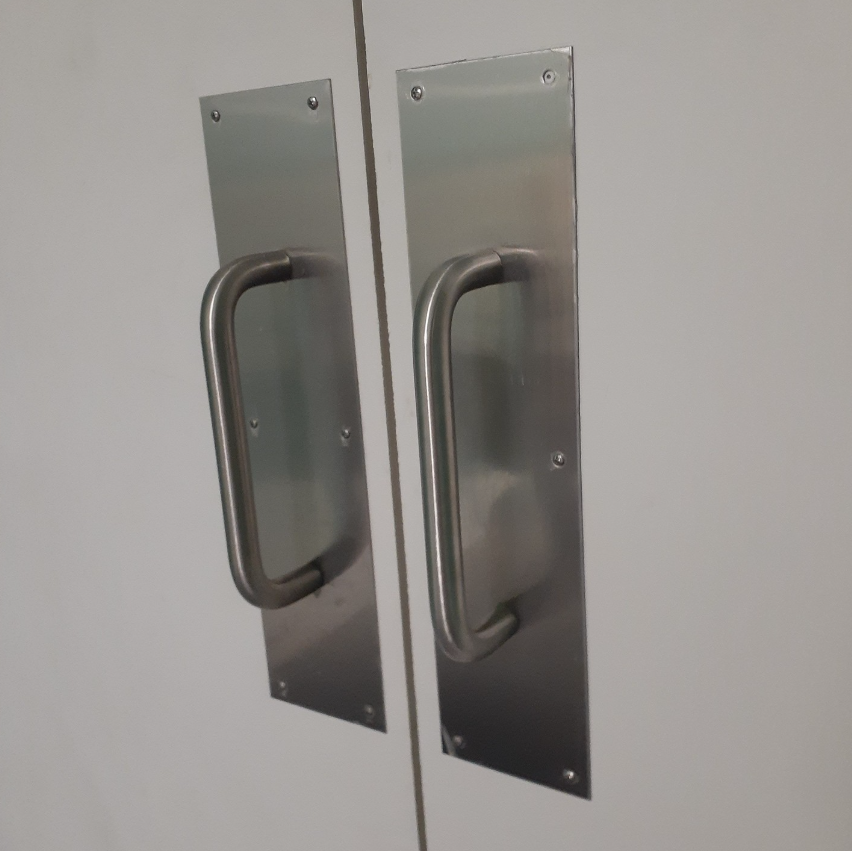 A pair of stainless steel door handles on a white door