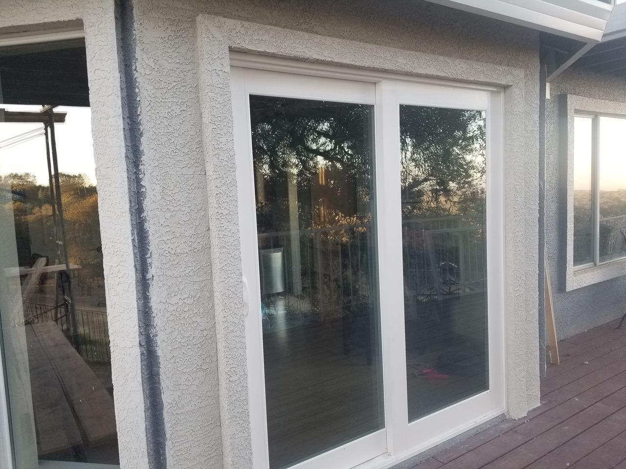 A white sliding glass door is open to a deck.