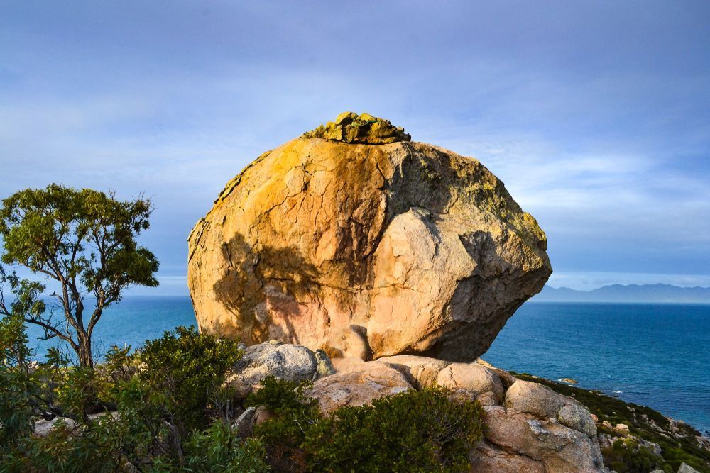 A Large Rock is Sitting on Top of a Cliff Overlooking the Ocean — Whitsunday Vogue Interiors in Bowen, QLD
