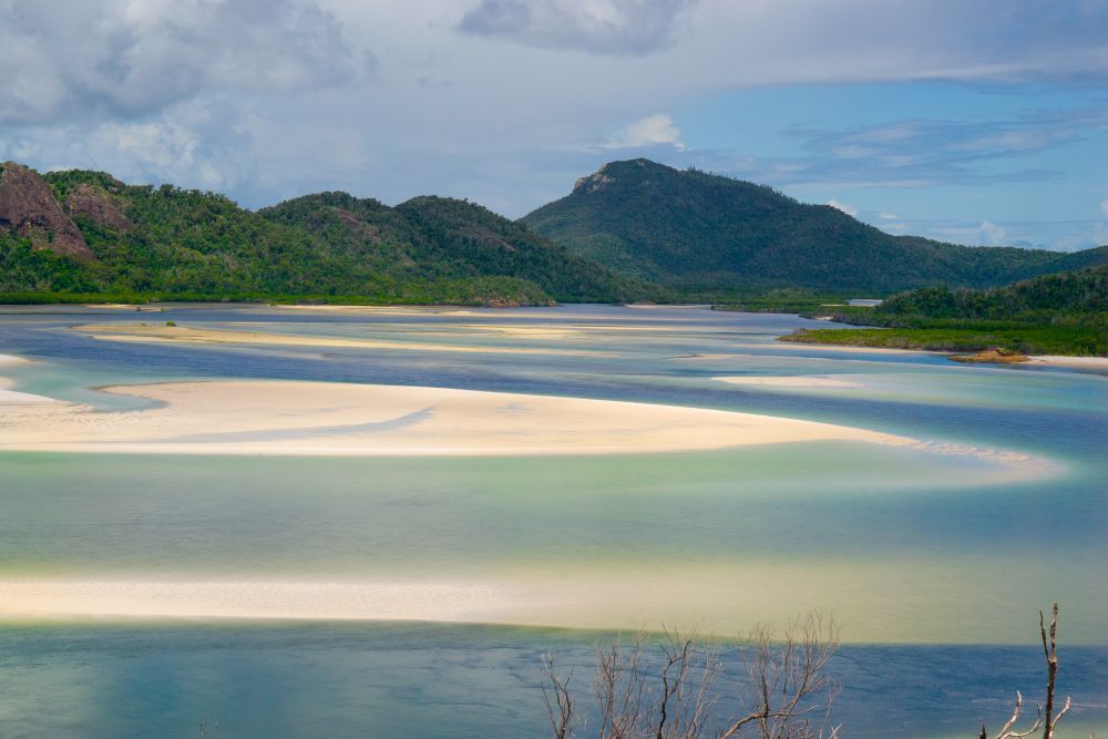 A Large Body of Water Surrounded by Mountains and Trees — Whitsunday Vogue Interiors in Airlie Beach, QLD