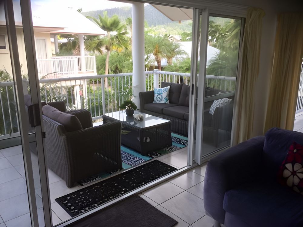 A Living Room With Sliding Glass Doors Leading to a Balcony — Whitsunday Vogue Interiors in Proserpine, QLD