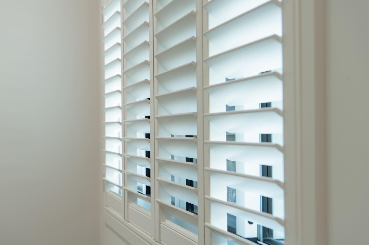 A Pair of White Shutters on a Window in a Room — Whitsunday Vogue Interiors in Cannonvale, QLD