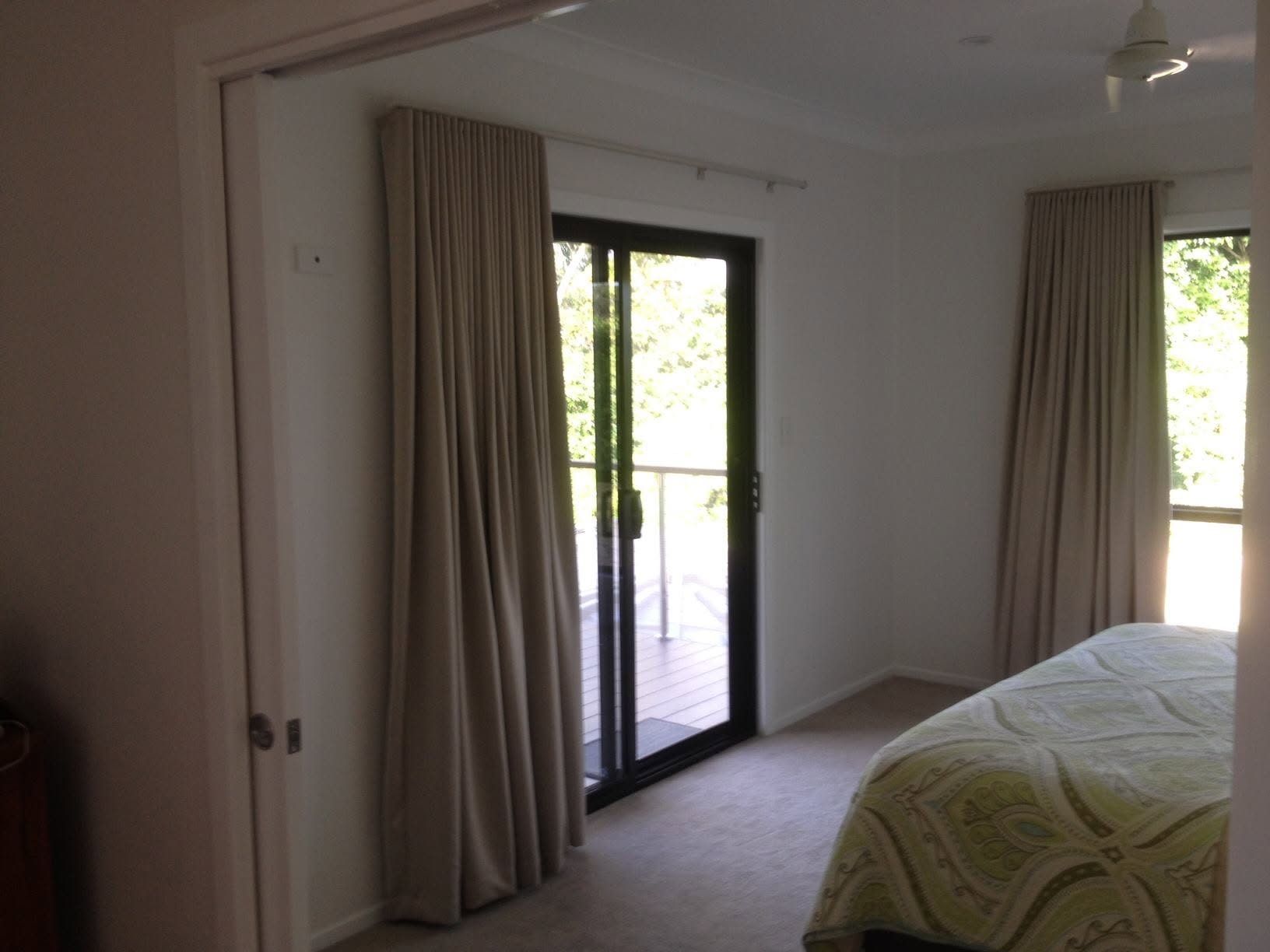 A Bedroom With a Bed and Sliding Glass Doors — Whitsunday Vogue Interiors in Cannonvale, QLD