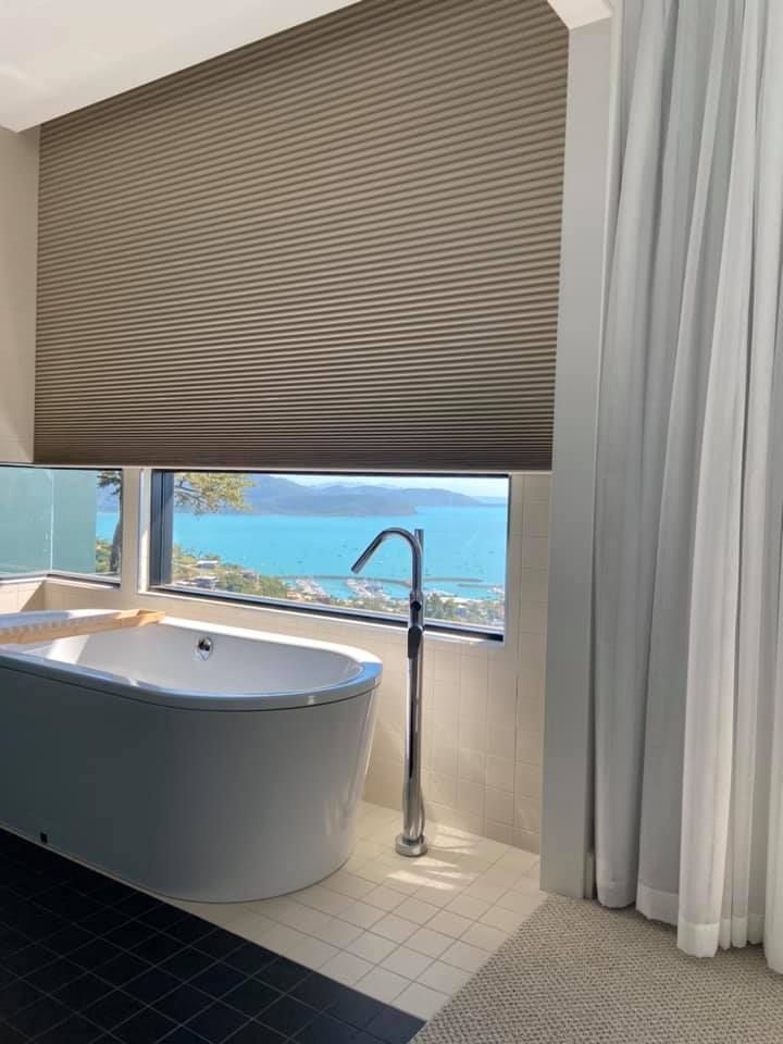 A Bathroom With a Tub and a Window With a View of the Ocean — Whitsunday Vogue Interiors in Bowen, QLD
