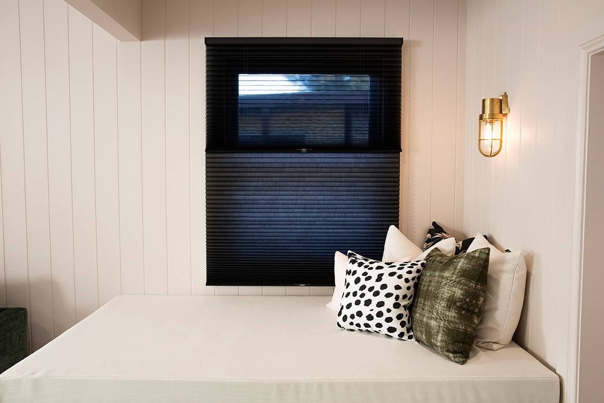 A Bed With Pillows and a Window in a Room — Whitsunday Vogue Interiors in Cannonvale, QLD