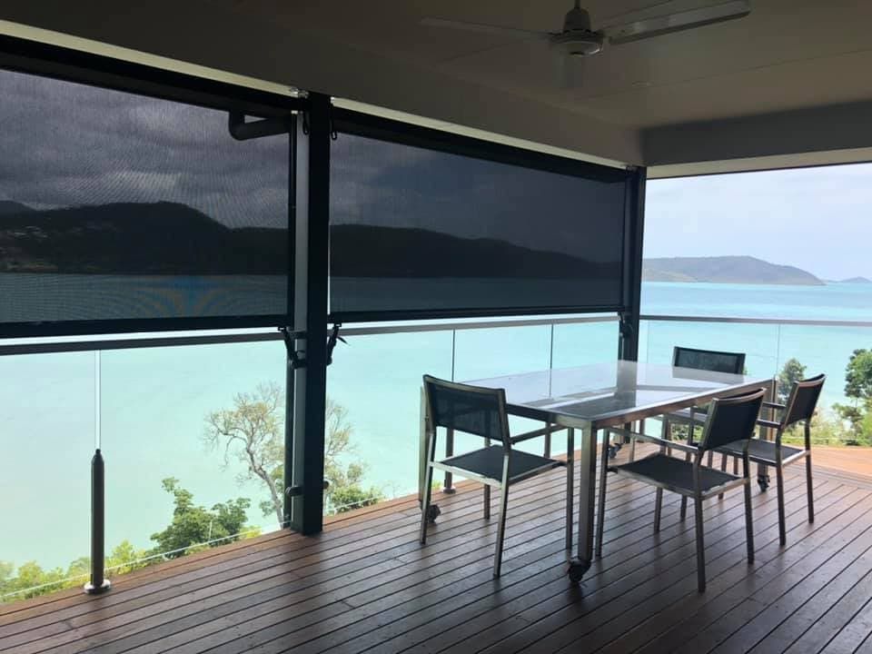 There is a Table and Chairs on the Deck With a View of the Ocean — Whitsunday Vogue Interiors in Cannonvale, QLD
