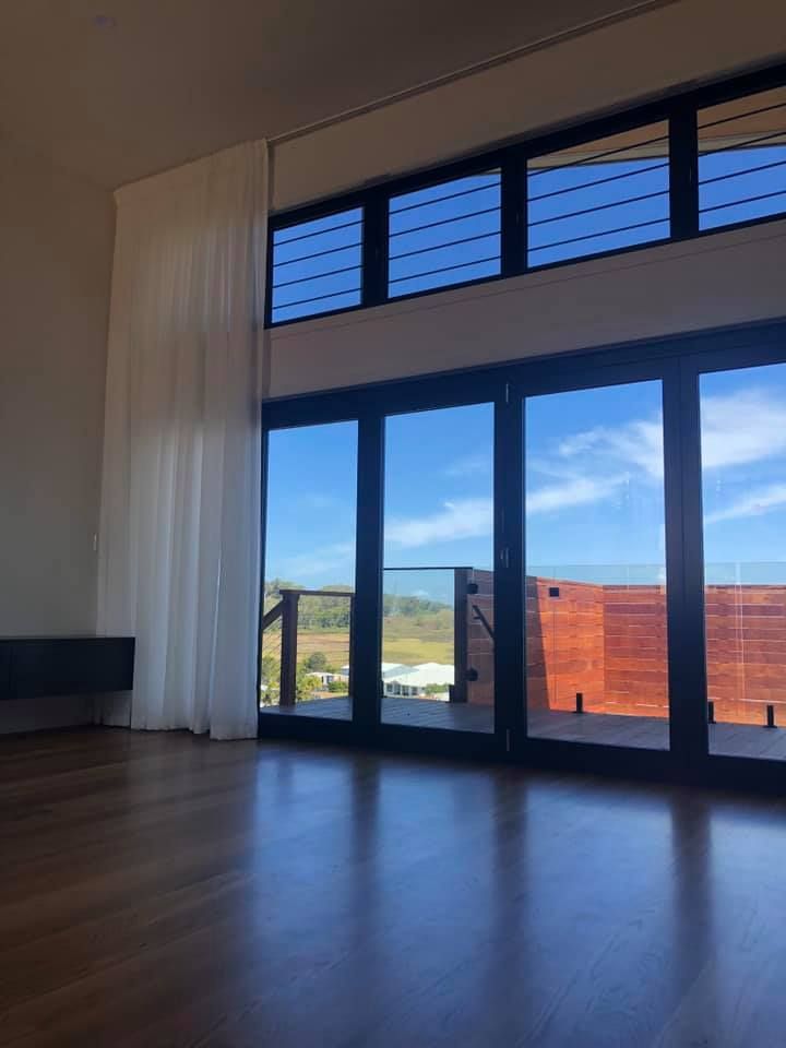 An Empty Room With a Lot of Windows and a Balcony — Whitsunday Vogue Interiors in Airlie Beach, QLD