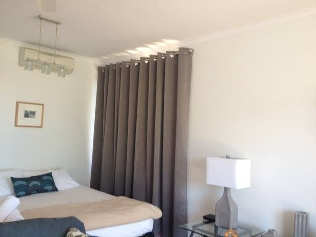 Bedroom With Gray Curtains, a Bed, Lamp, and a Small Picture on the Wall — Whitsunday Vogue Interiors in Cannonvale, QLD