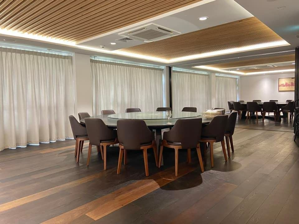 A Dining Room With a Large Round Table, Chairs, and Wooden Floor — Whitsunday Vogue Interiors in Cannonvale, QLD