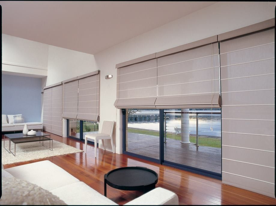 Living Room With Light-colored Roman Shades Over Large Windows — Whitsunday Vogue Interiors in Cannonvale, QLD