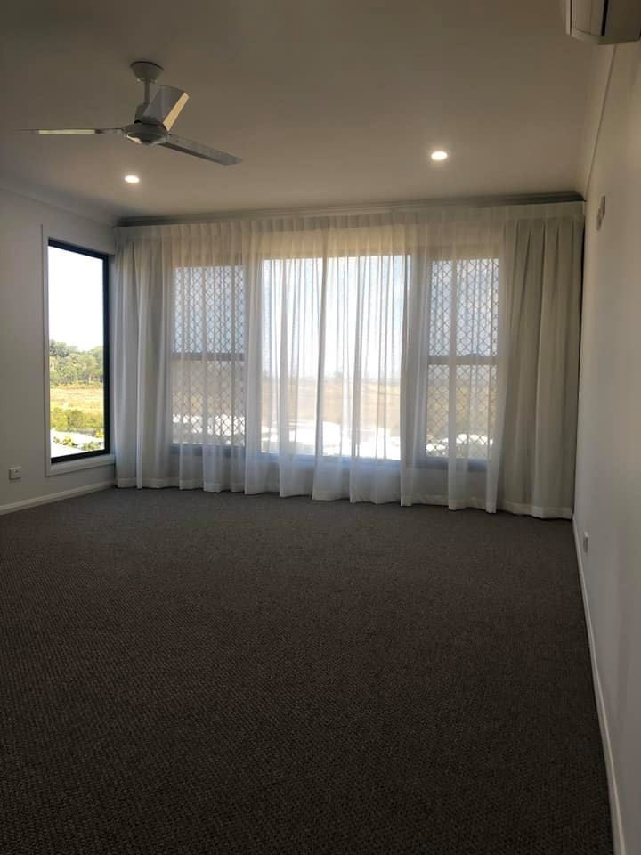 Living Room With Light-colored Roman Shades Over Large Windows — Whitsunday Vogue Interiors in Cannonvale, QLD