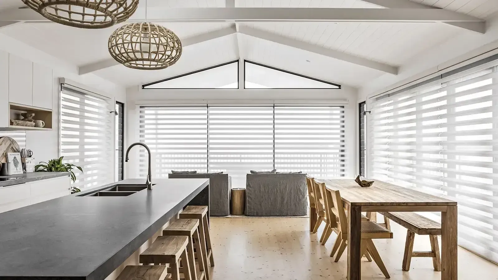 a Kitchen With a Long Table and Stools and Shutters on the Windows — Whitsunday Vogue Interiors in Cannonvale, QLD