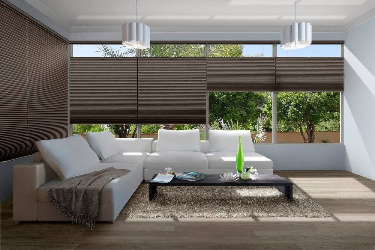 A Living Room With a White Sofa, Brown Blinds, and a View of Trees Outside — Whitsunday Vogue Interiors in Cannonvale, QLD