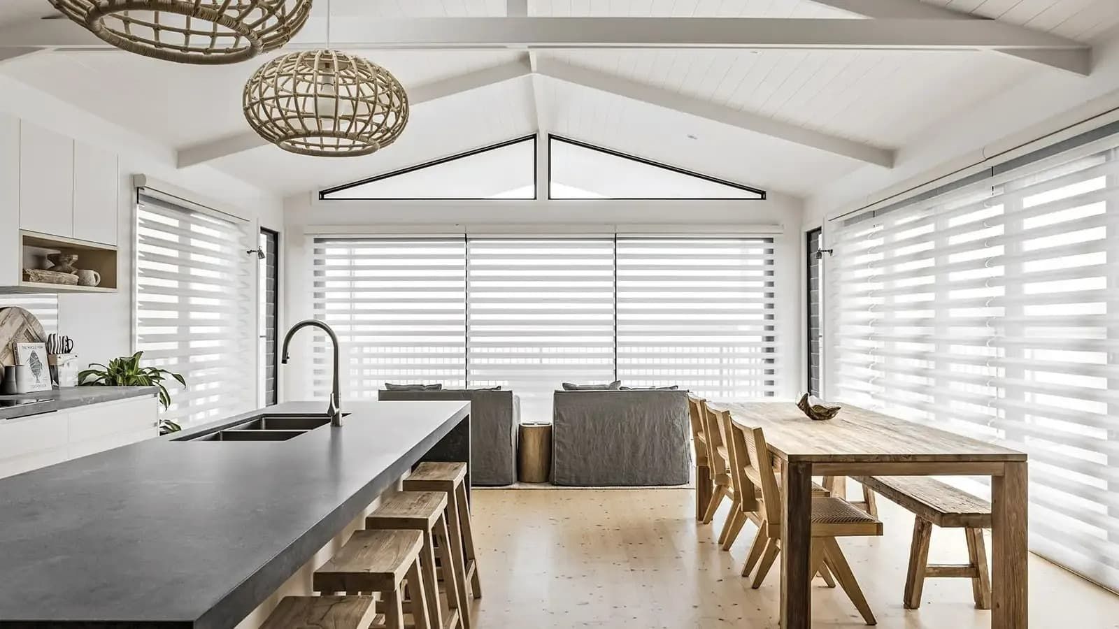 Spacious, White Kitchen-dining Room With Wooden Accents, Long Countertop, and Large Window Shutters — Whitsunday Vogue Interiors in Cannonvale, QLD