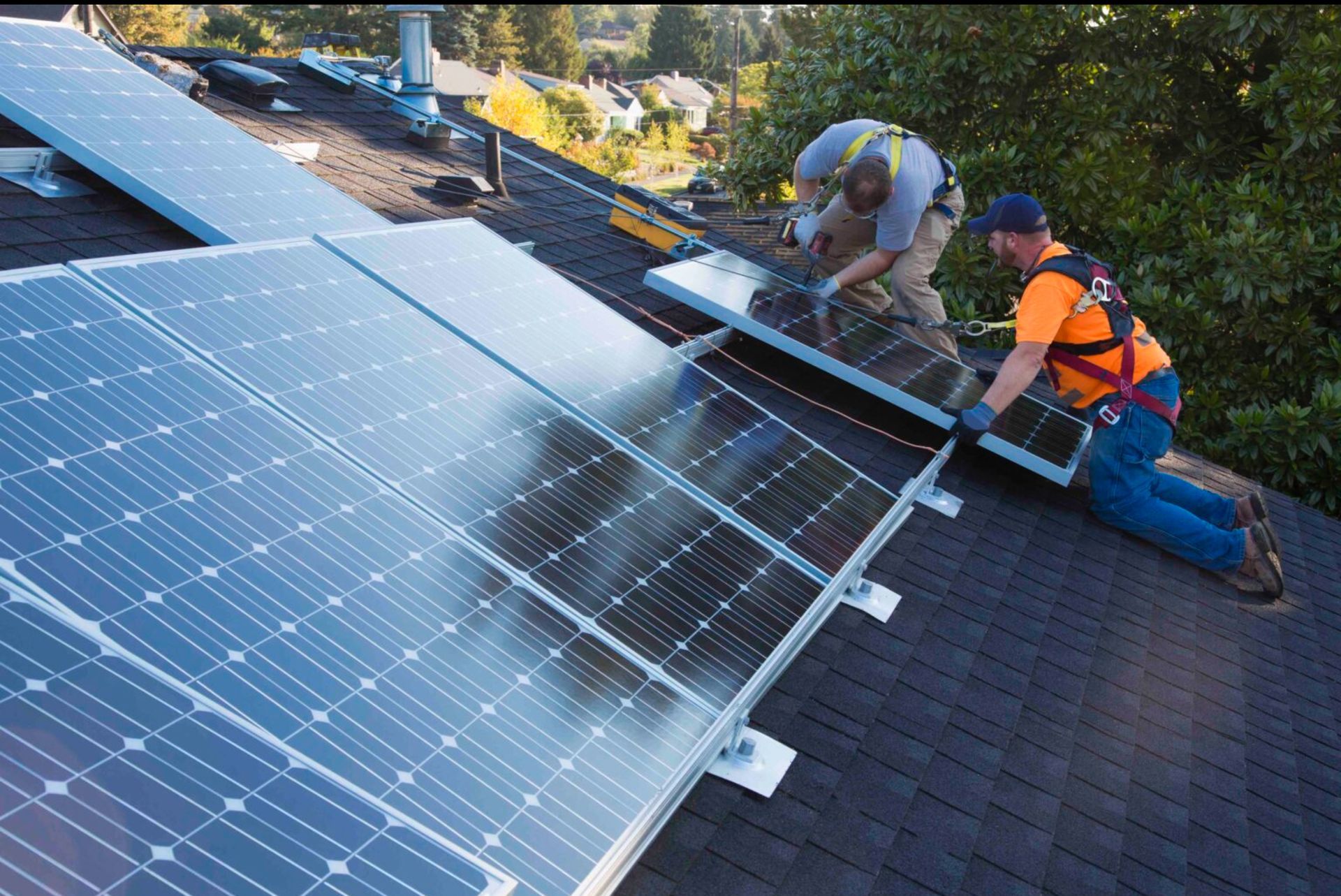 Two men are installing solar panels on a roof