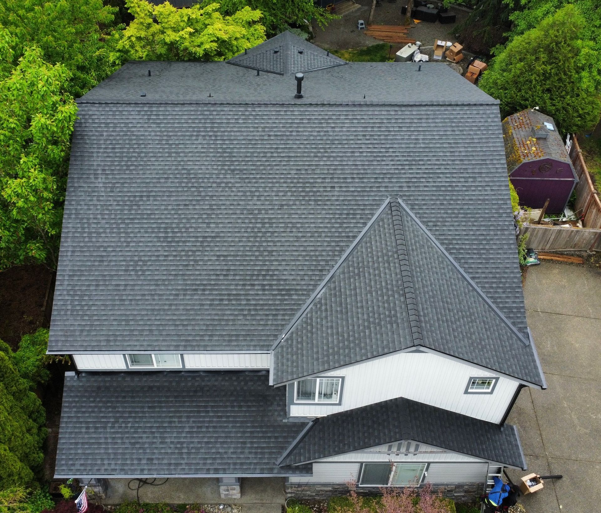 An aerial view of a house with a gray roof
