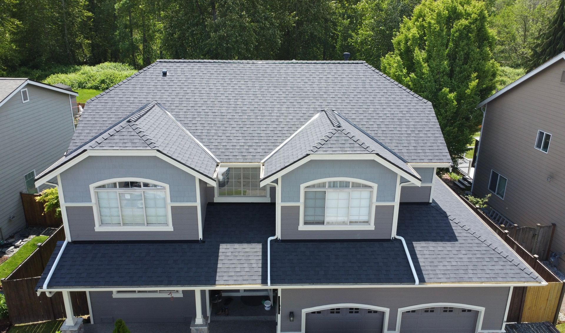 An aerial view of a large house with a gray roof