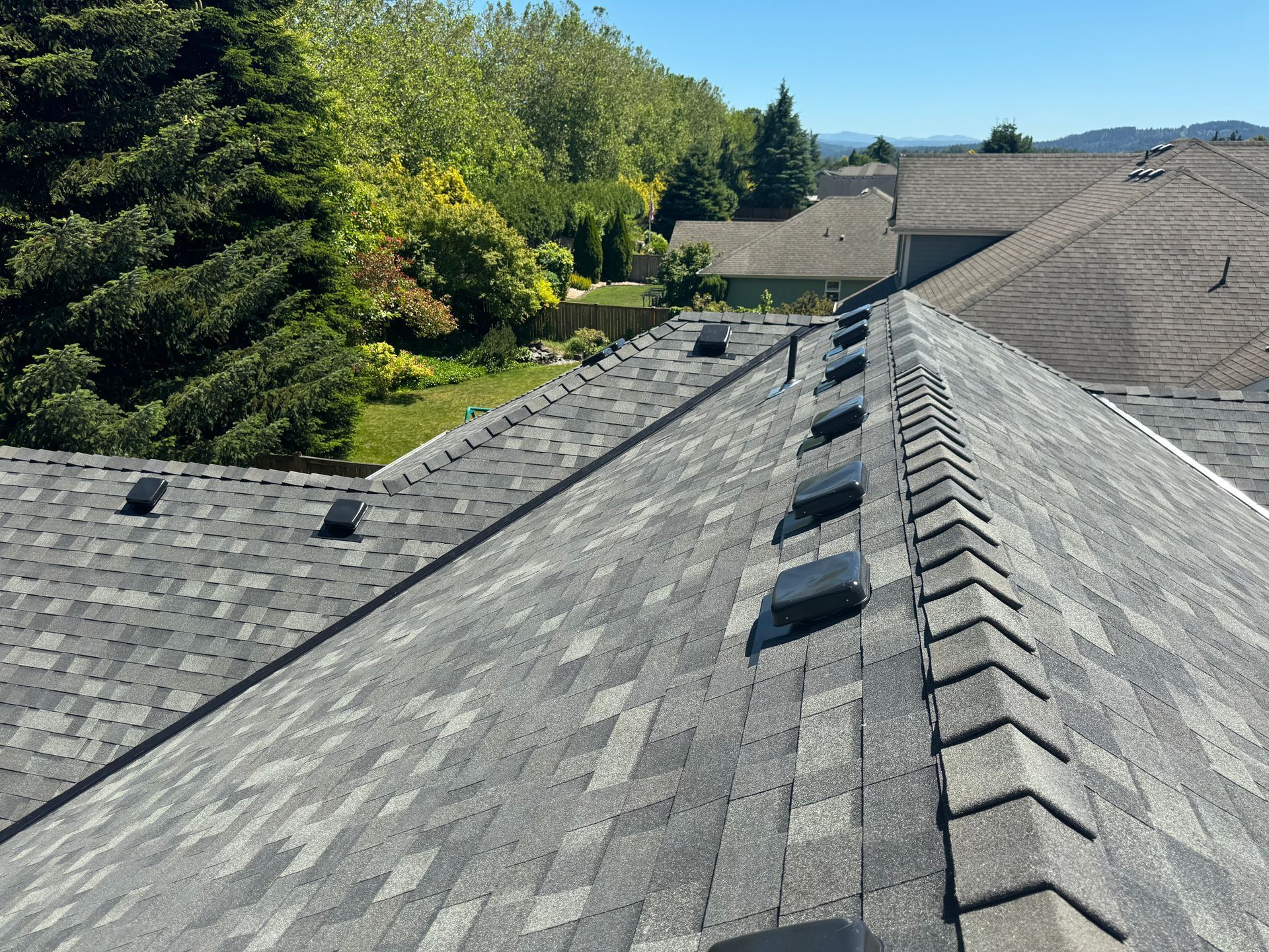 A close up of a roof with shingles and a skylight