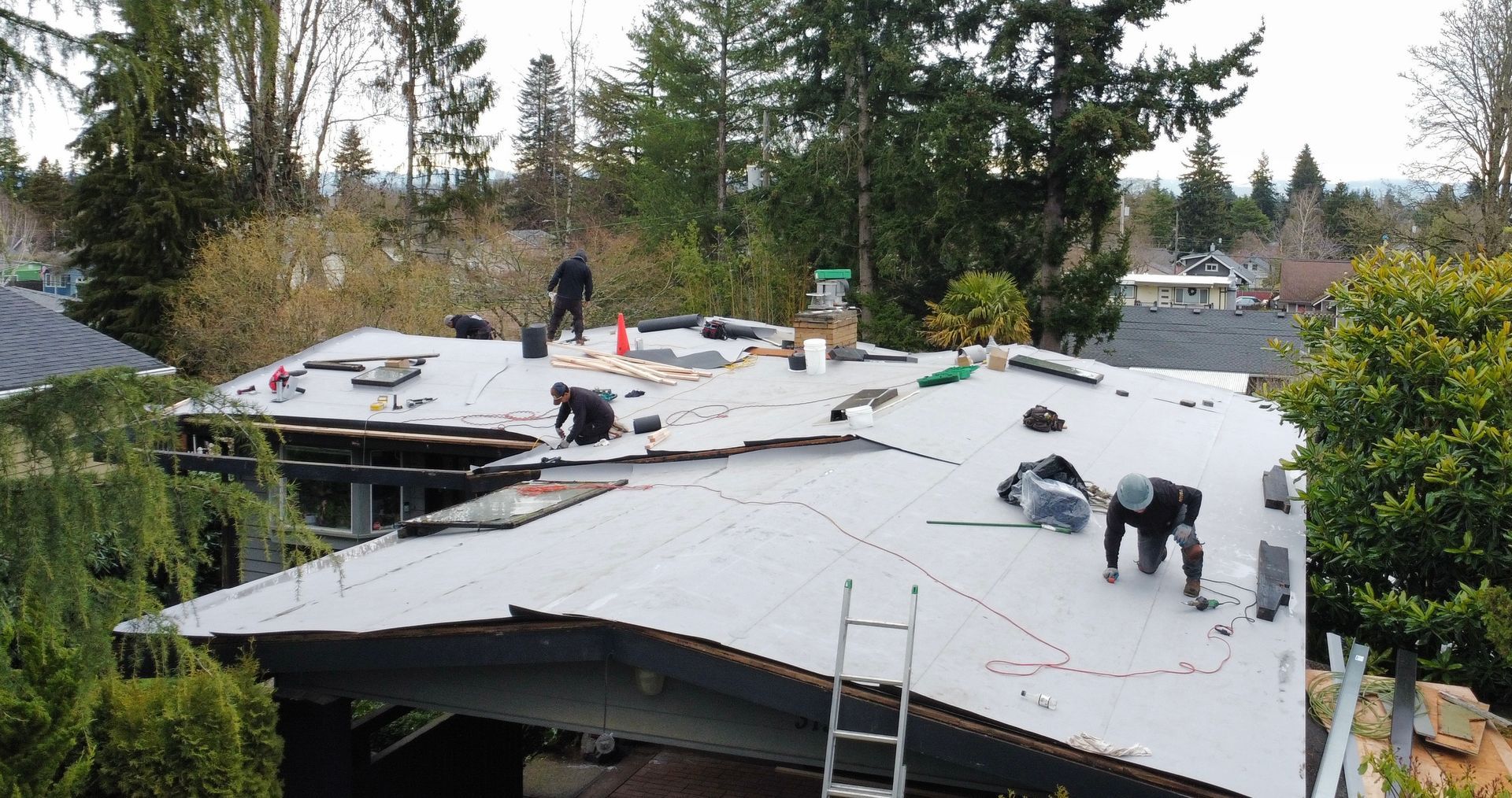 A group of people are working on the roof of a house.