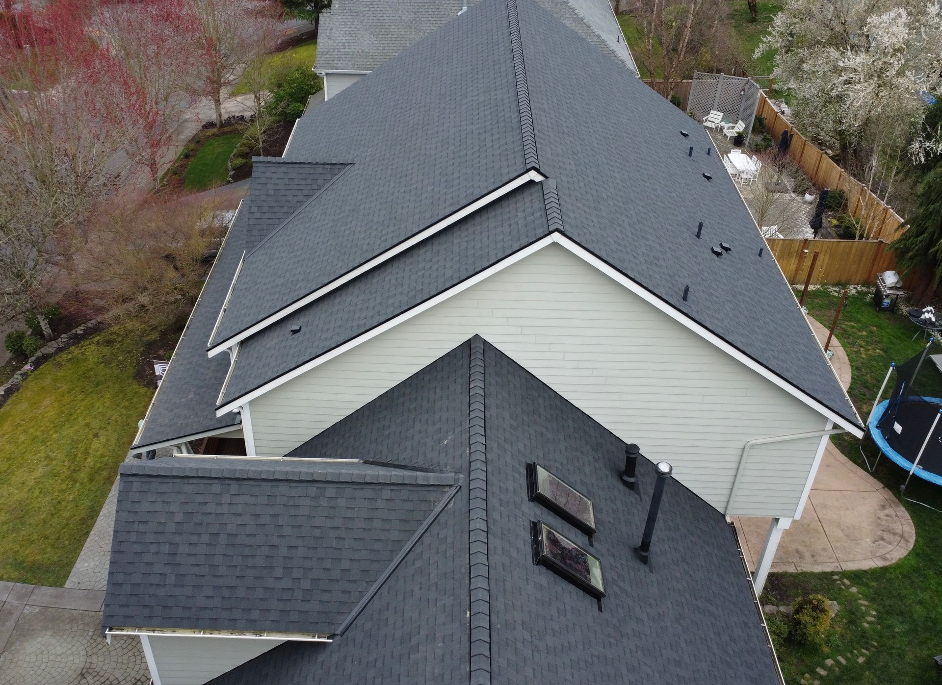 An aerial view of a house with a trampoline in the backyard.