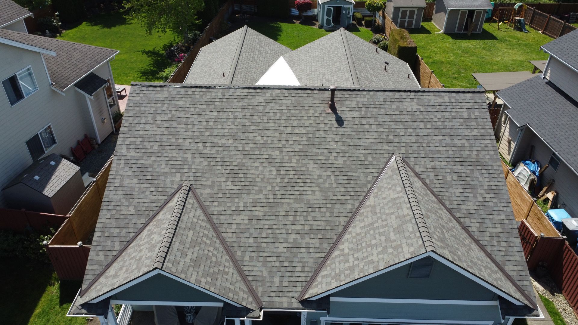 An aerial view of a house with a gray roof