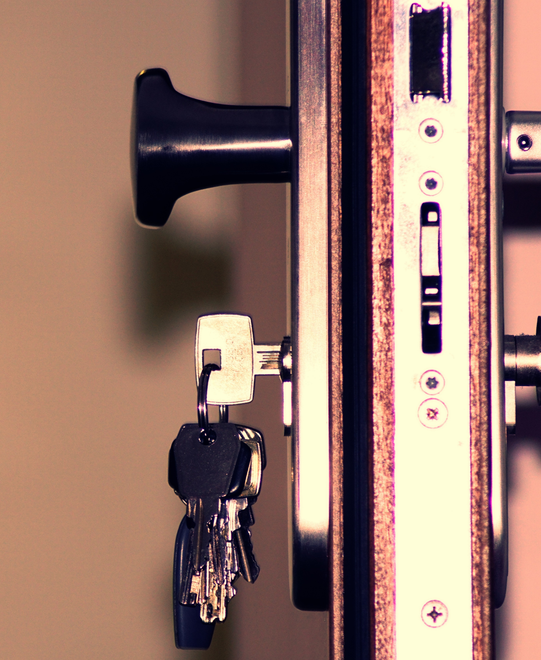 A close up of a door lock with keys in it