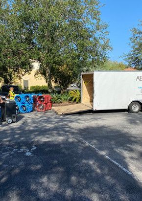 A white truck is parked in a parking lot next to a bunch of boxes.