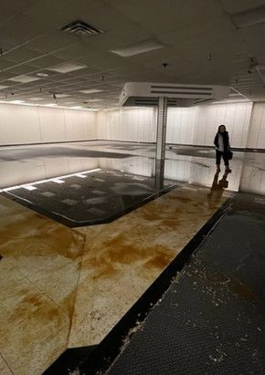 A woman is standing in a large empty room.