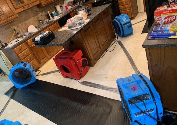 A kitchen with a lot of appliances on the floor.