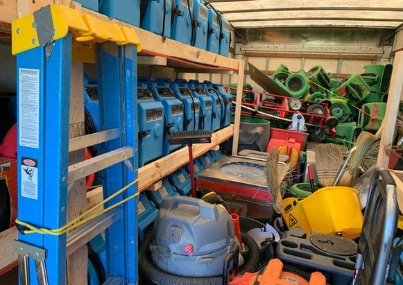 A truck filled with lots of tools and a ladder.
