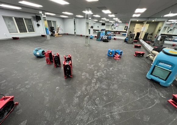 A large gym with a lot of equipment on the floor.