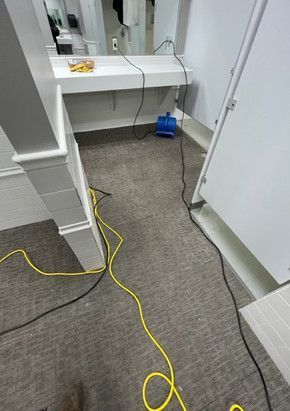 A bathroom with a sink and a yellow cord.